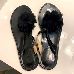 Black patent leather flip flops with flower accent
